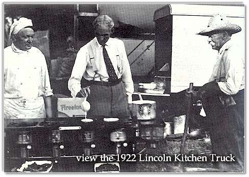 Henry Ford tries his hand at cooking flapjacks. At the rear are two of the special trucks which accompanied the campers.